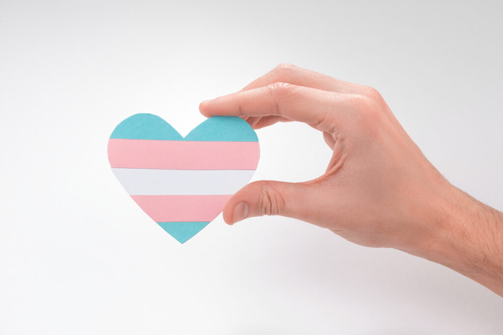 hand holding a heartshaped transgender flag