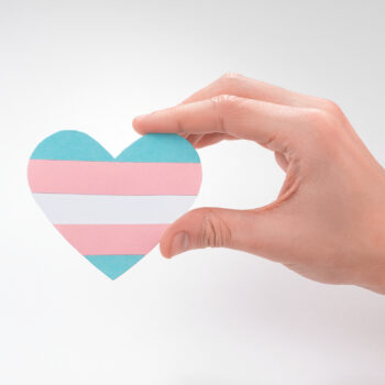 hand holding a heartshaped transgender flag