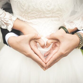 A newlywed couple joining hands and discussing name change options after marriage